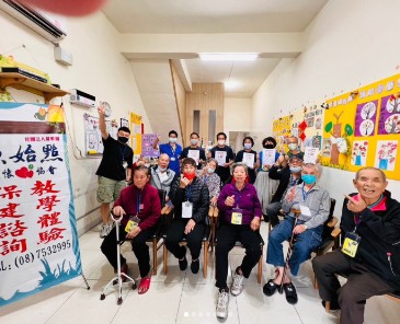 九如樂智社區服務據點內，長輩與志工於聖誕公益活動合影，左側可見協會活動布條。